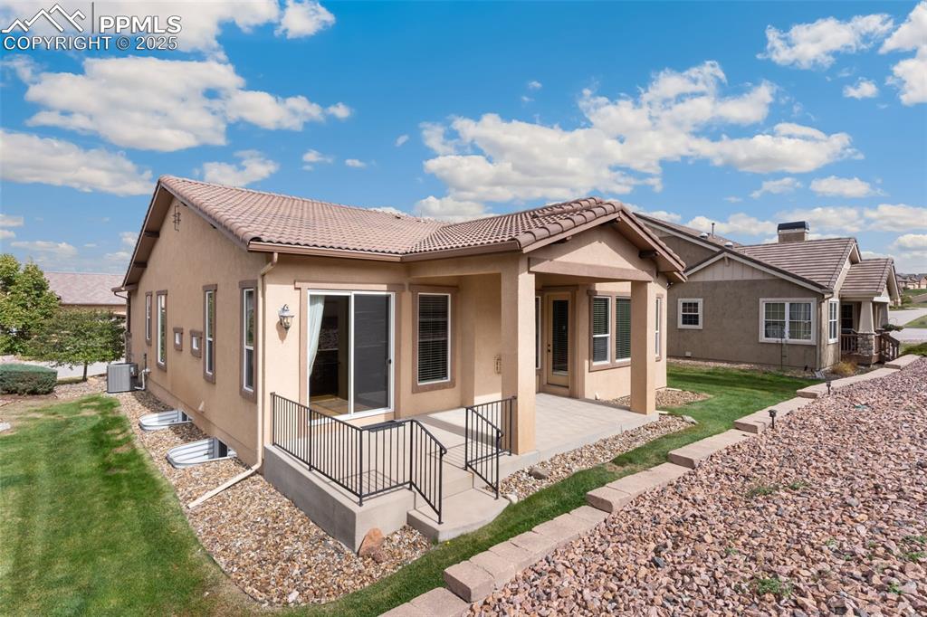 Image 26 of 27: Back of house with a patio, stucco siding, a lawn, and a tile roof