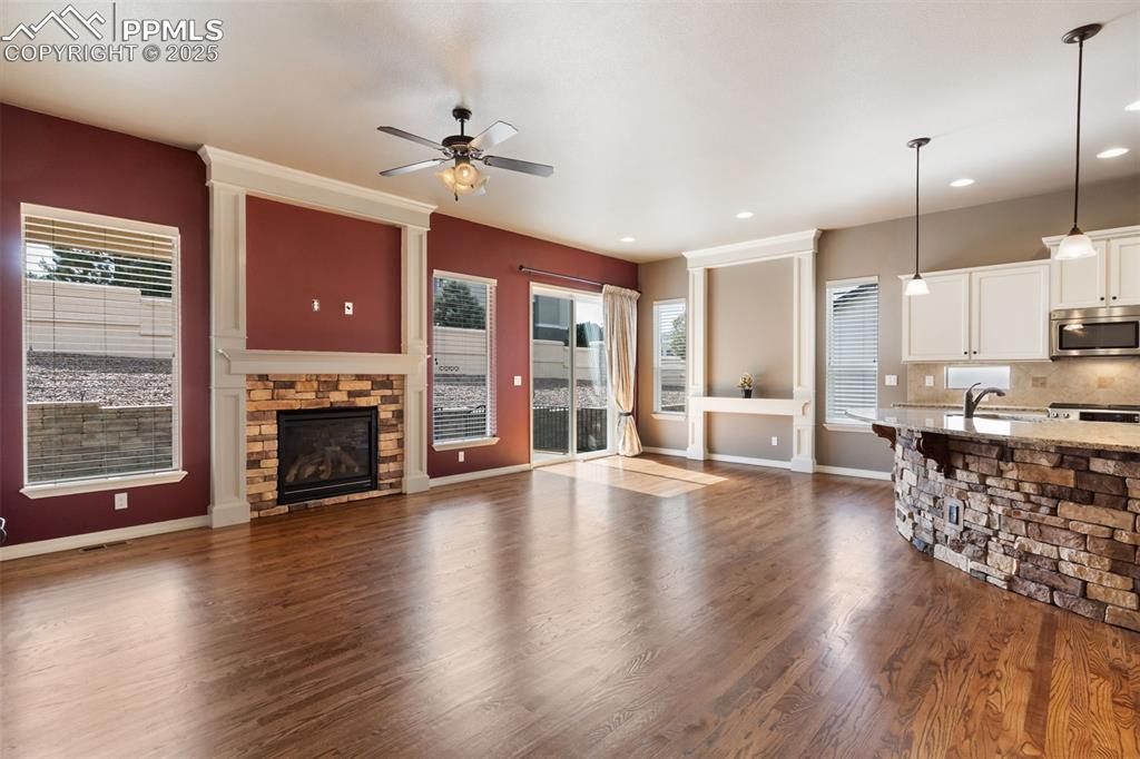 Image 4 of 27: Unfurnished living room with a fireplace, dark wood finished floors, ceilin