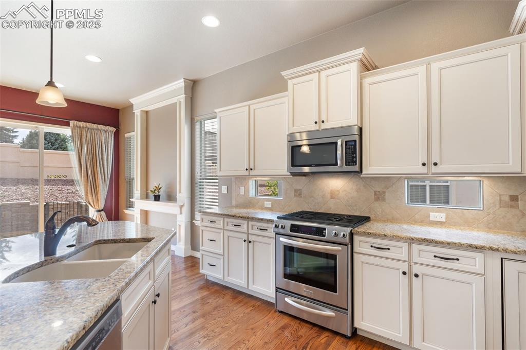 Image 9 of 27: Kitchen featuring appliances with stainless steel finishes, light wood-styl