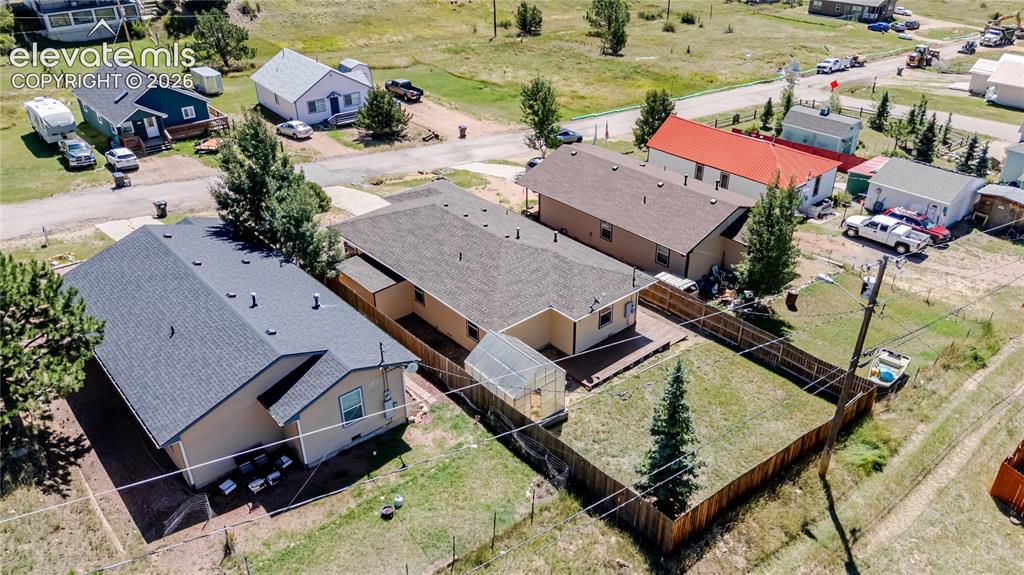 Image 7 of 27: Aerial of backyard with greenhouse, gated dog run on side, and large storag