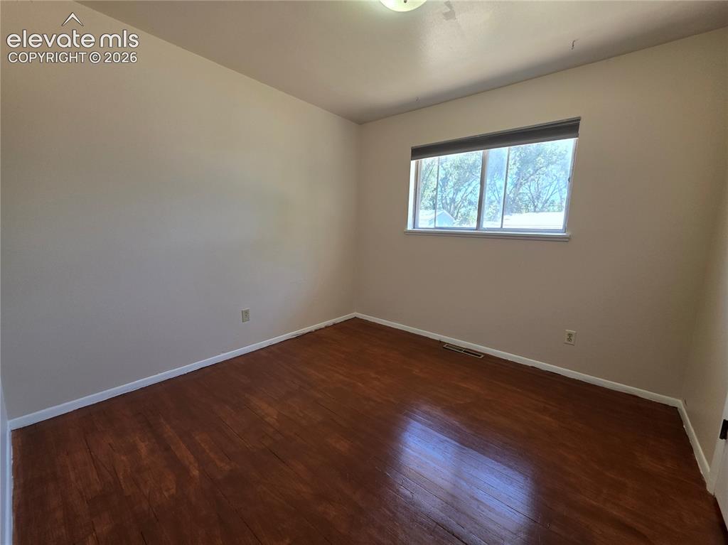 Image 10 of 17: Hardwood-finish flooring with light-toned walls and white trim