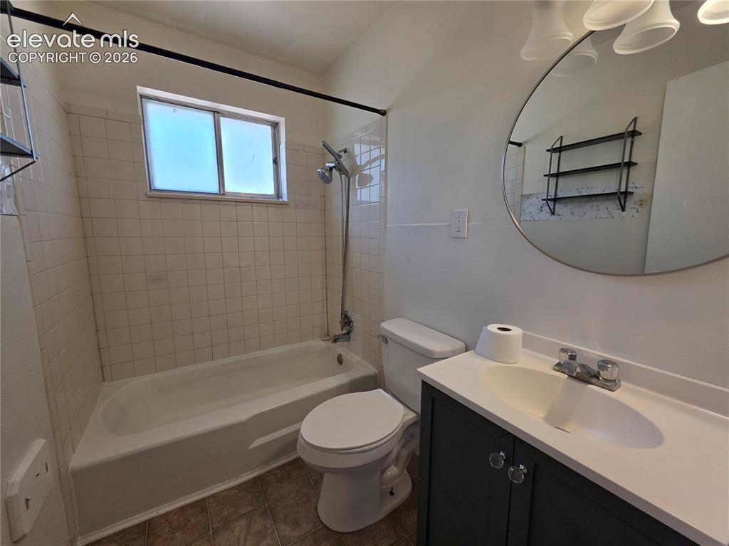 Image 12 of 17: Full bathroom featuring a rectangular window, white tiled shower surround,