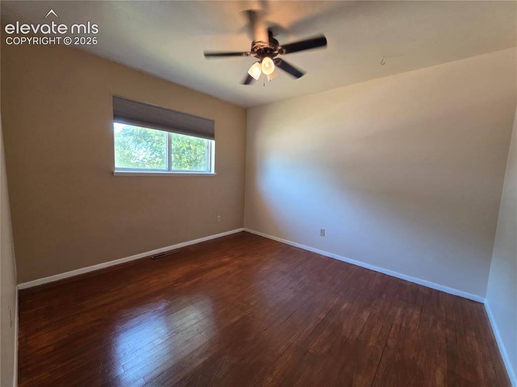 Image 13 of 17: Room featuring wood-finish flooring, a ceiling fan with integrated lighting