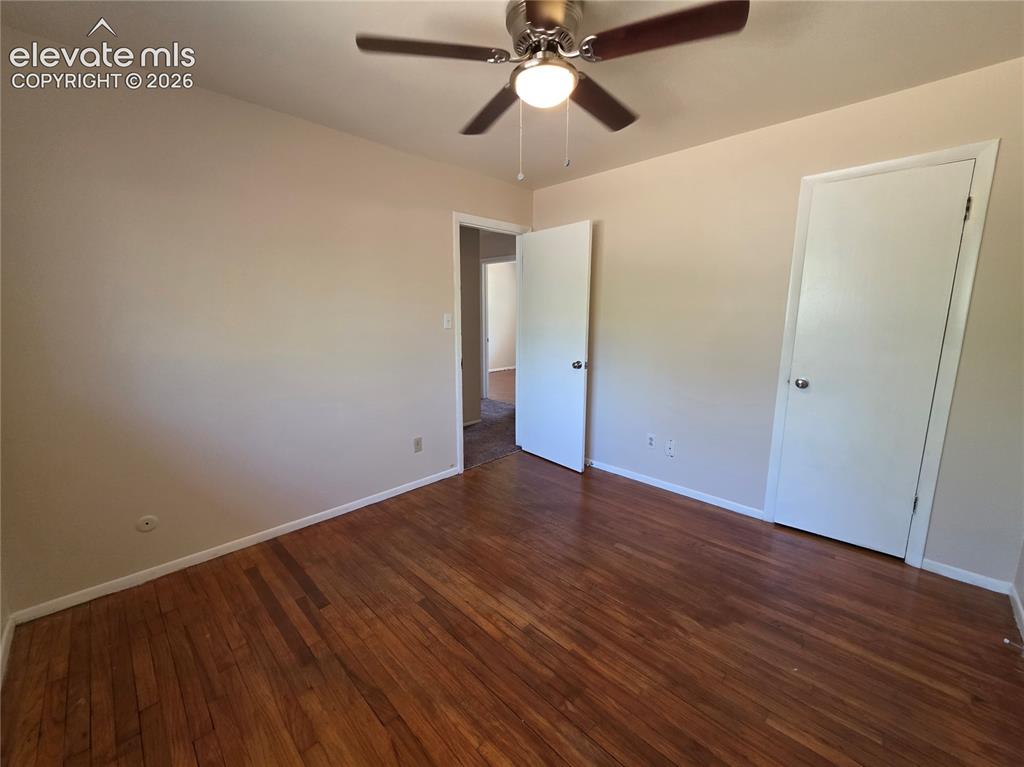 Image 16 of 17: Bright interior room featuring wood-finish flooring and a ceiling fan with