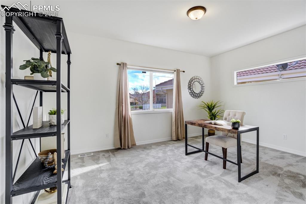 Image 11 of 50: The second room on the main level is a bedroom or is currently staged as an