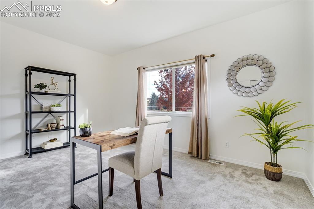 Image 27 of 50: This main level bedroom is currently staged as an office.
