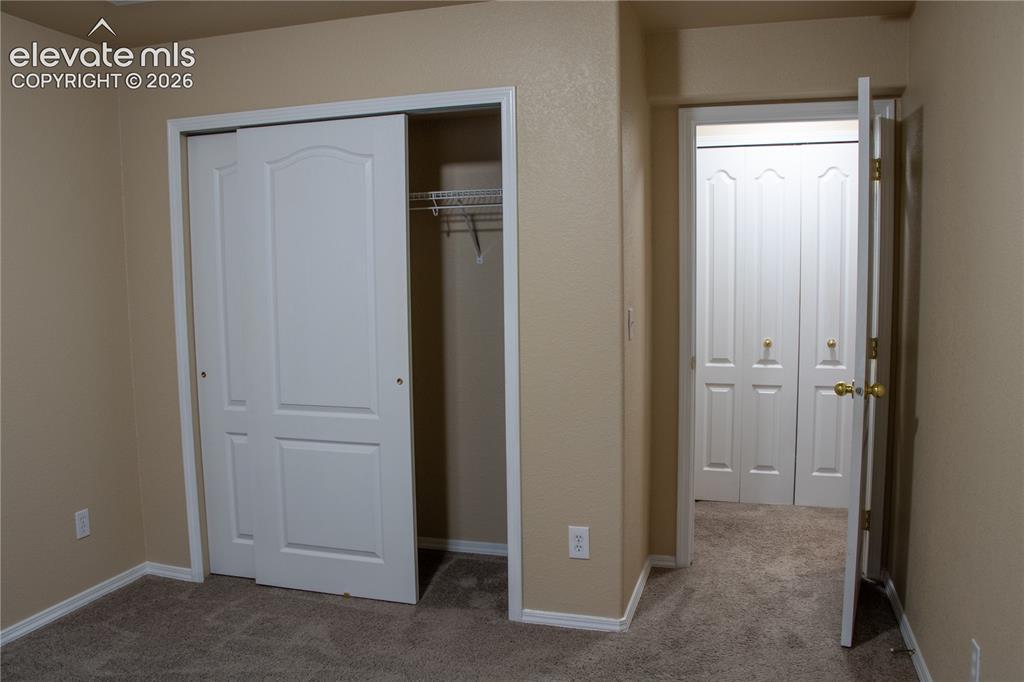 Image 26 of 40: Room featuring neutral wall tones, textured carpeting, white baseboards, an