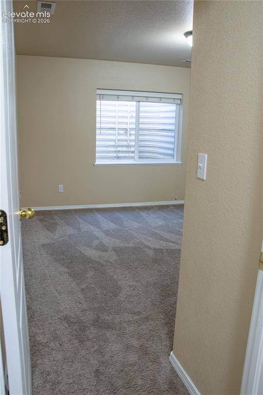 Image 27 of 40: Carpeted room with a single window featuring horizontal blinds