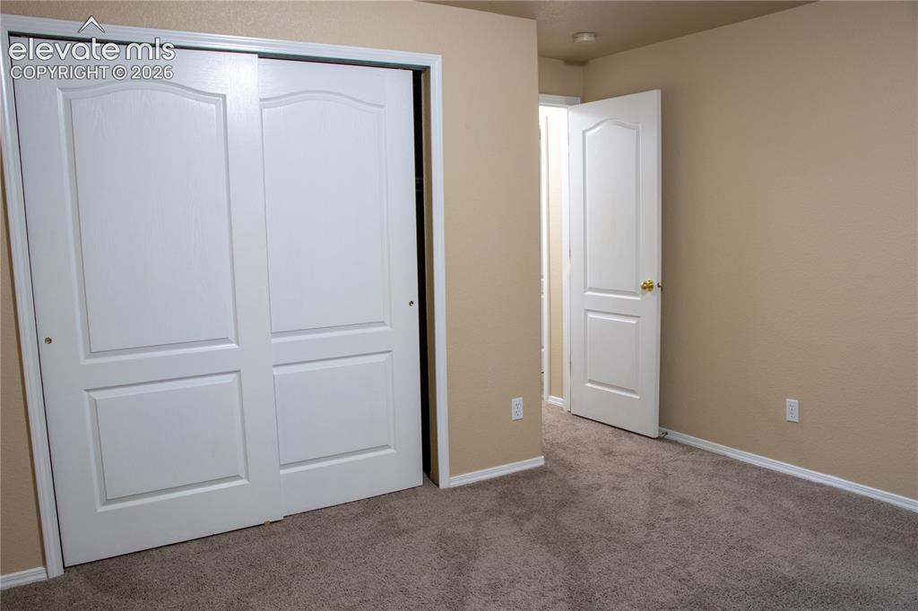 Image 28 of 40: Bedroom featuring neutral-toned walls, carpet flooring, and white trim
