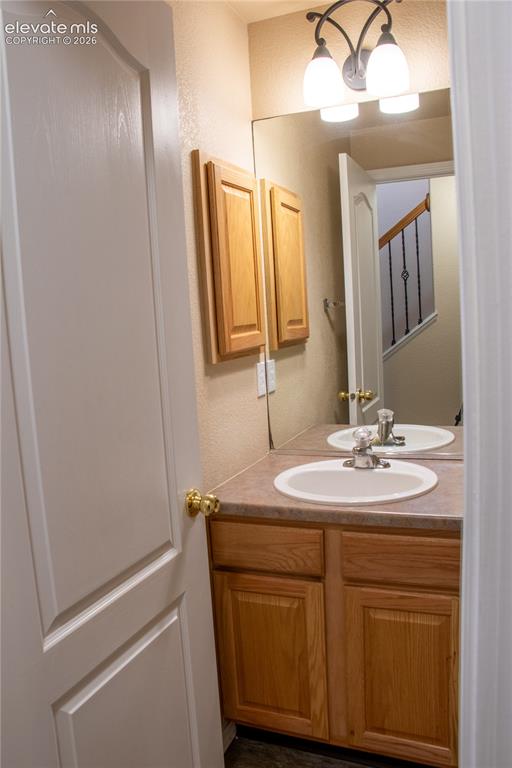 Image 31 of 40: Vanity with a built-in sink, wood-finish cabinetry, and a countertop