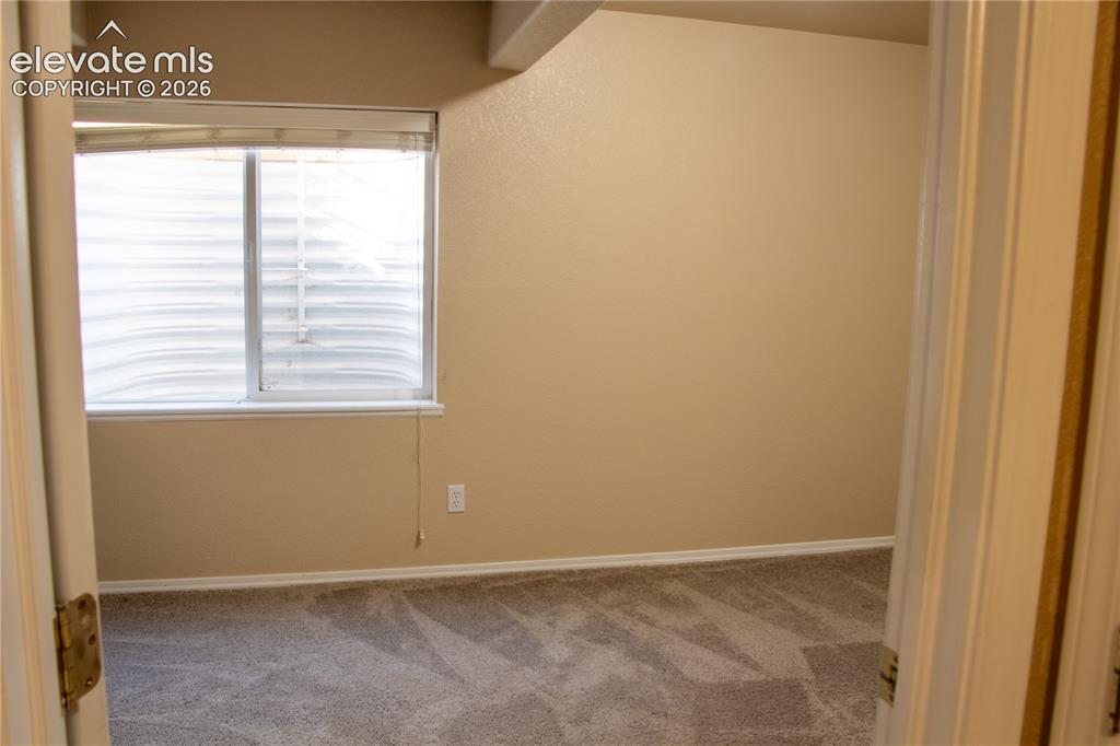 Image 33 of 40: Neutral-toned walls complement the gray carpeting