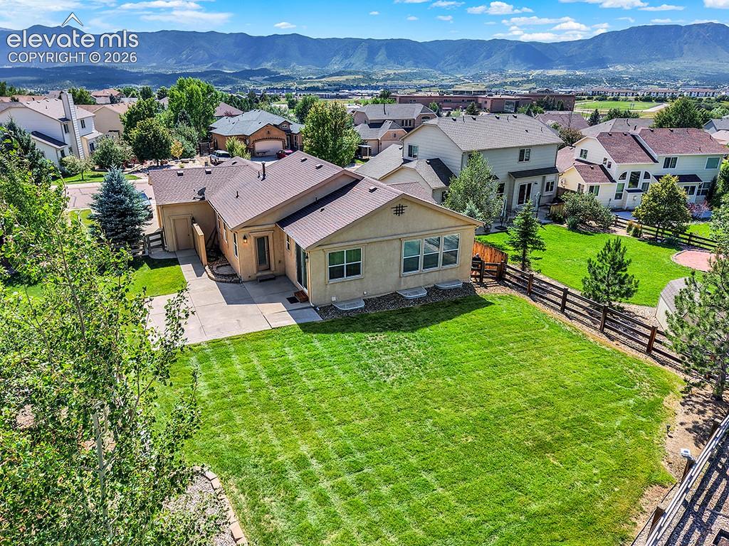 Image 38 of 40: Expansive rear yard featuring a manicured lawn, established landscaping, an