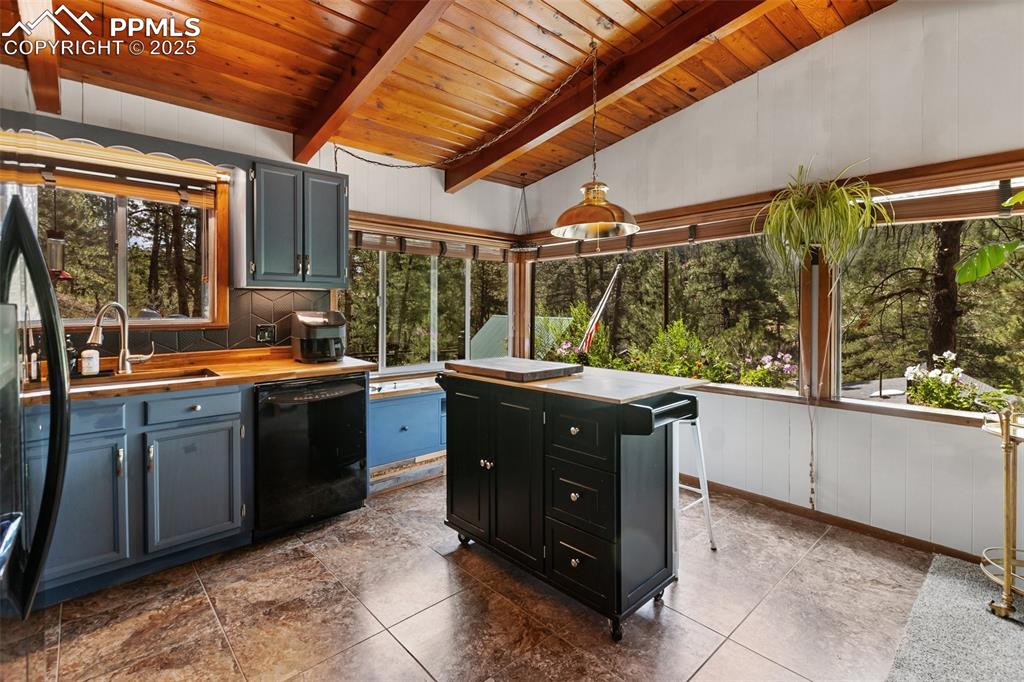 Image 3 of 46: Kitchen featuring hanging light fixtures, black appliances, wood counters,