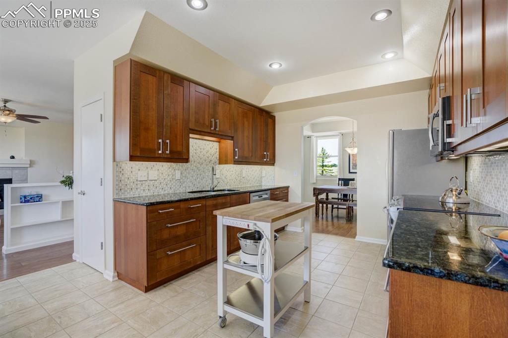 Image 12 of 50: Kitchen with granite counters, decorative backsplash, and stainless steel a