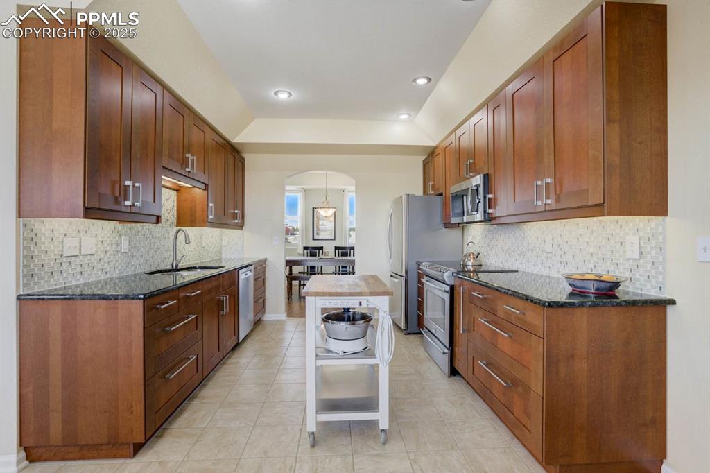 Image 13 of 50: Kitchen with arched walkway to the formal dining room
