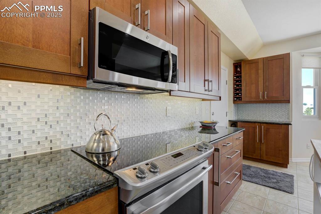 Image 15 of 50: Kitchen featuring updated soft close cabinets, decorative backsplash, and s