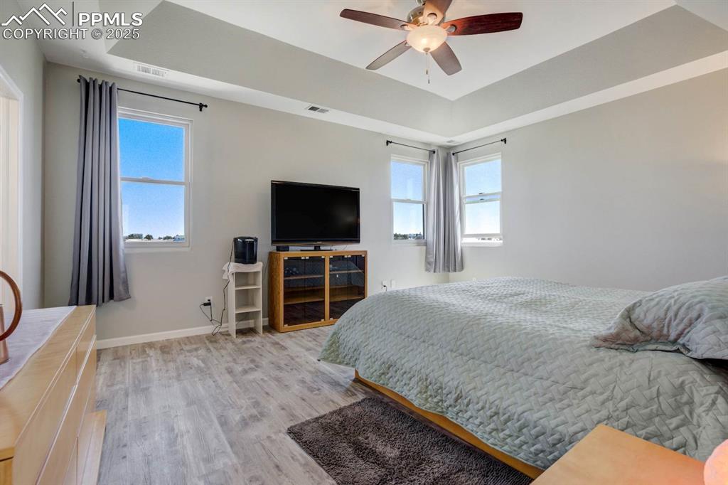Image 20 of 50: Primary bedroom with a raised coffered ceiling