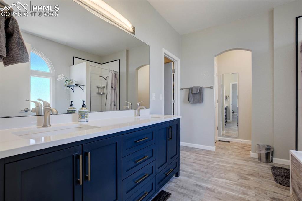 Image 23 of 50: Primary bathroom en-suite with double vanity, and walk-in closet entrance