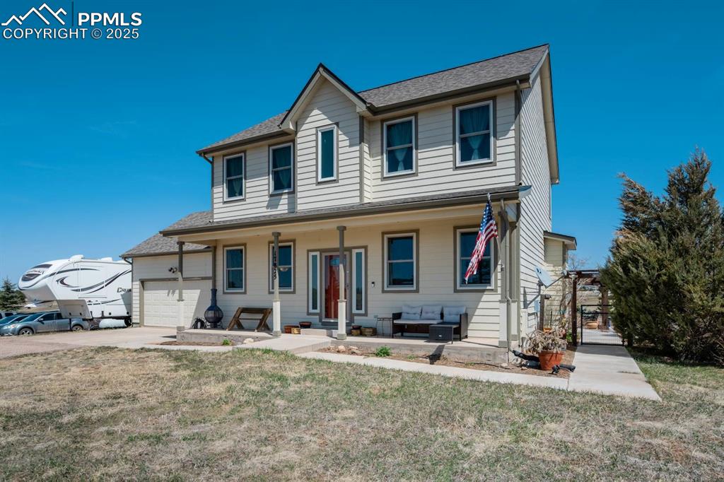 Image 3 of 50: View of front of property with a front yard, extra parking, and covered por