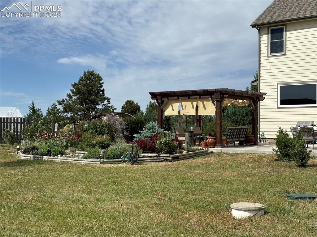 Image 37 of 50: View of yard with a pergola, fence, and a patio area