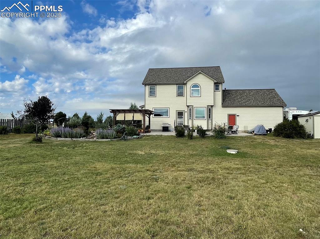 Image 39 of 50: Back of property with a patio, a lawn, and a pergola