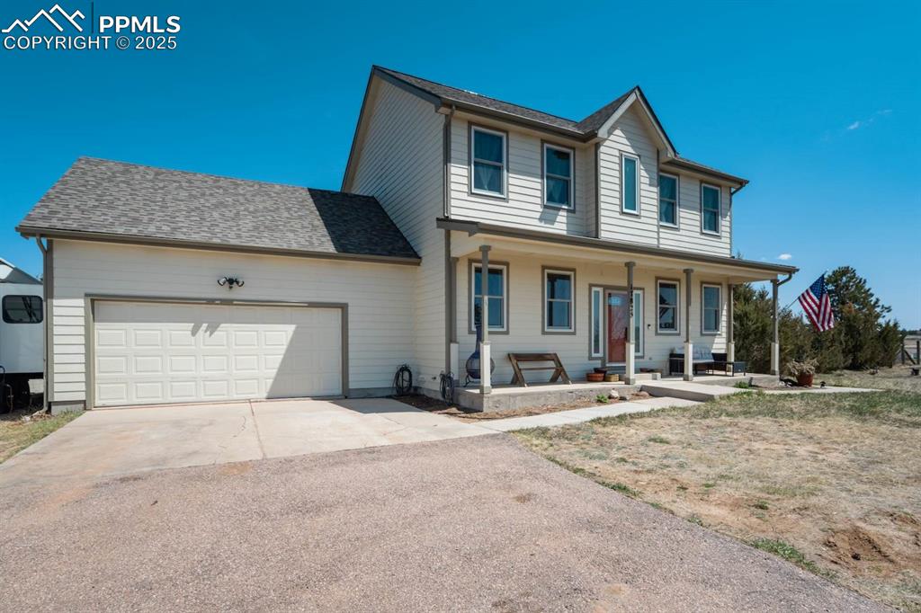 Image 4 of 50: View of front of house with an attached garage, and covered porch