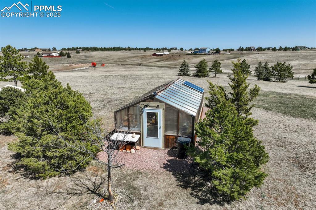 Image 43 of 50: Aerial view of greenhouse and back property