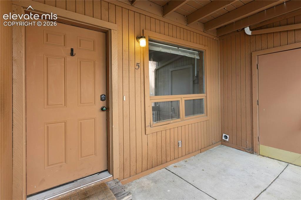 Image 1 of 31: Entry door with electronic keypad lock, vertical wood siding, and recessed