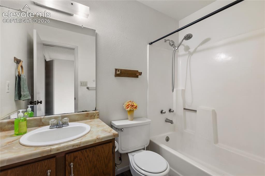 Image 10 of 33: Bathroom featuring a white tub/shower combination with a handheld showerhea