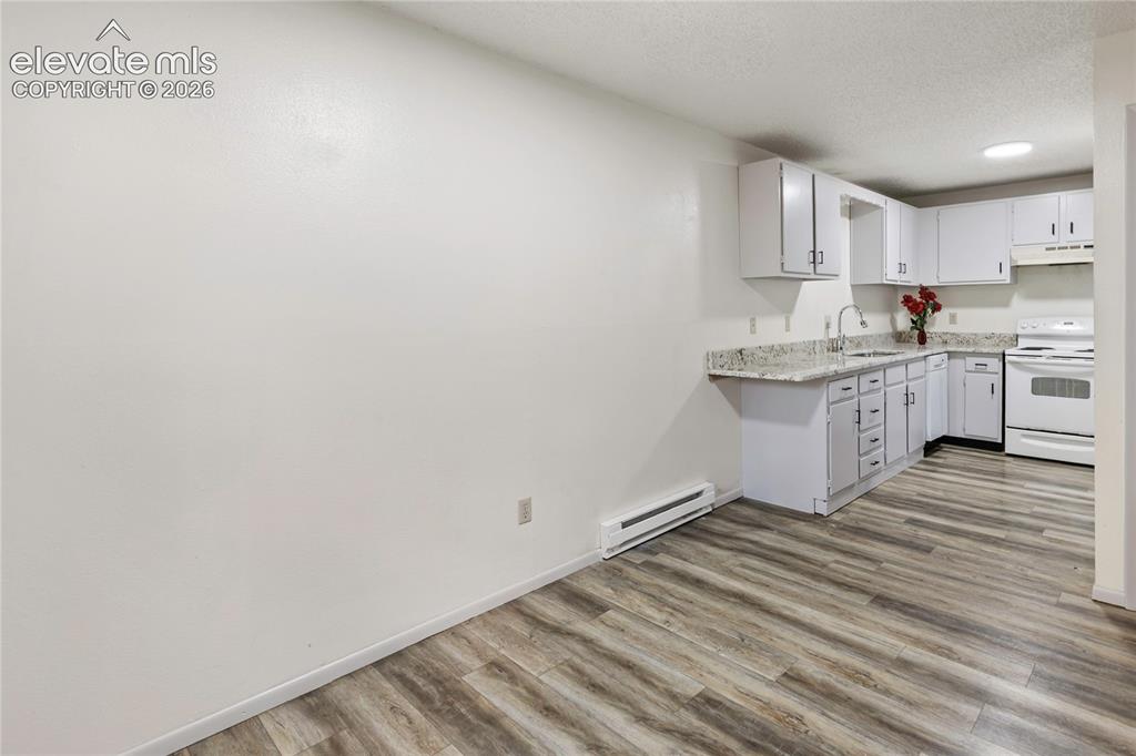 Image 11 of 33: Kitchen featuring white cabinetry, light-toned countertops, a stainless ste