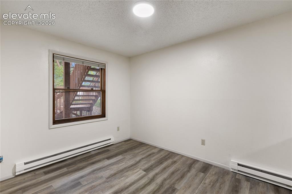 Image 16 of 33: Room featuring wood-finish flooring, a window with exterior stair access, w