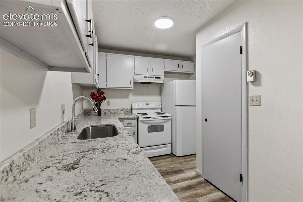 Image 18 of 31: Kitchen featuring light-toned granite-look countertops, a stainless steel s