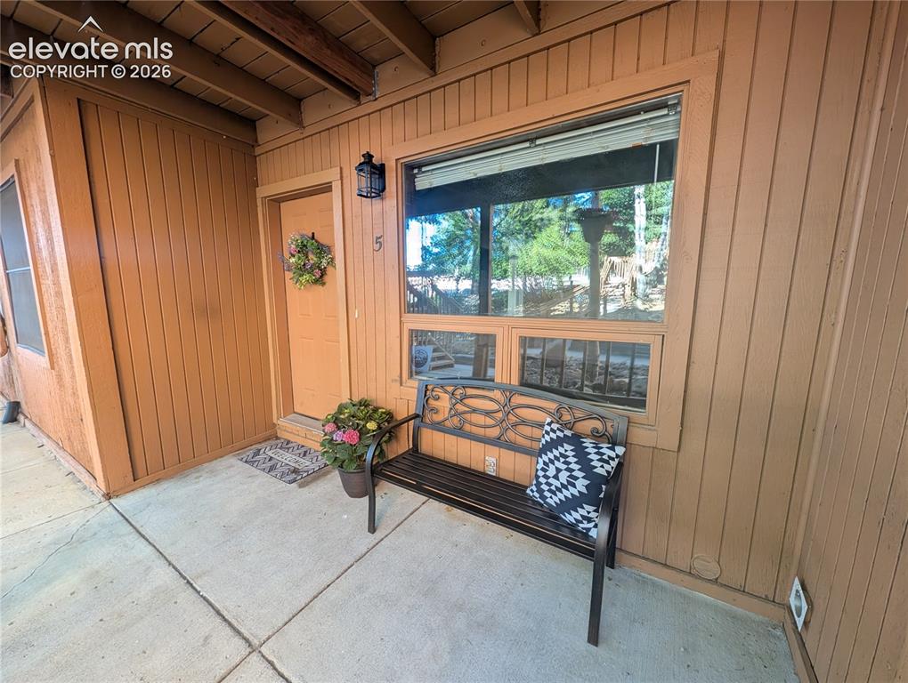 Image 2 of 33: Entryway with wood panel siding, a solid wood door, and a multi-pane window
