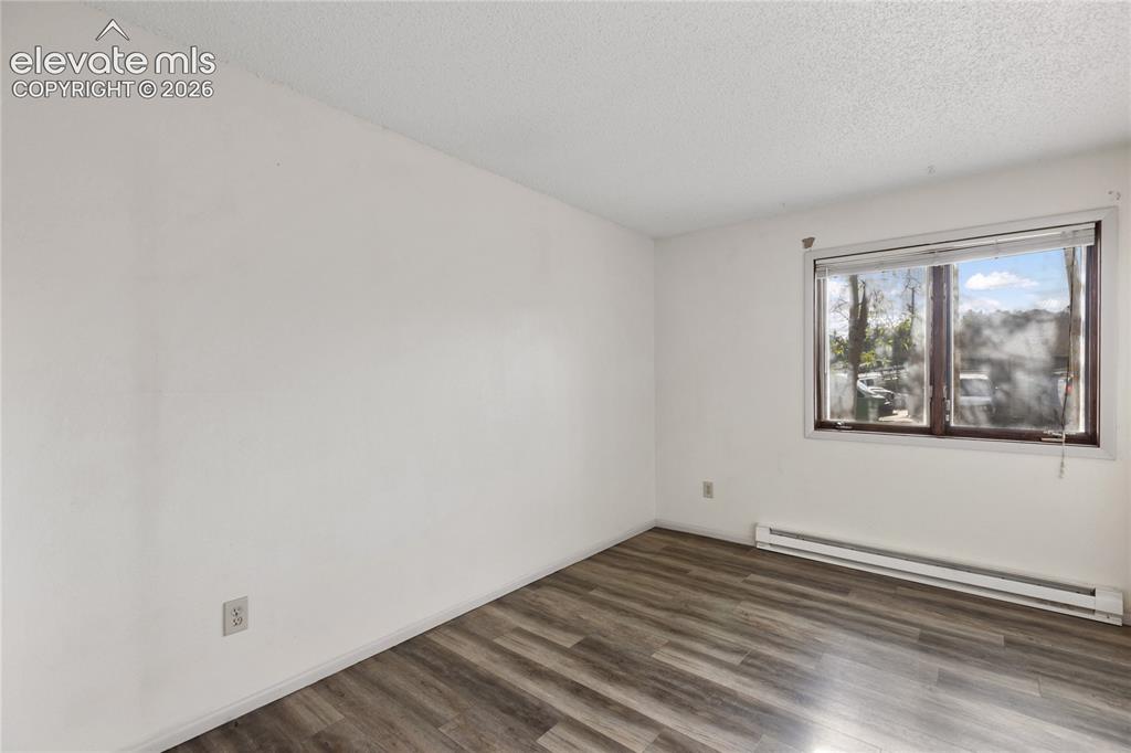 Image 22 of 33: Room featuring wood-finish flooring, white walls, a single window, and a ba
