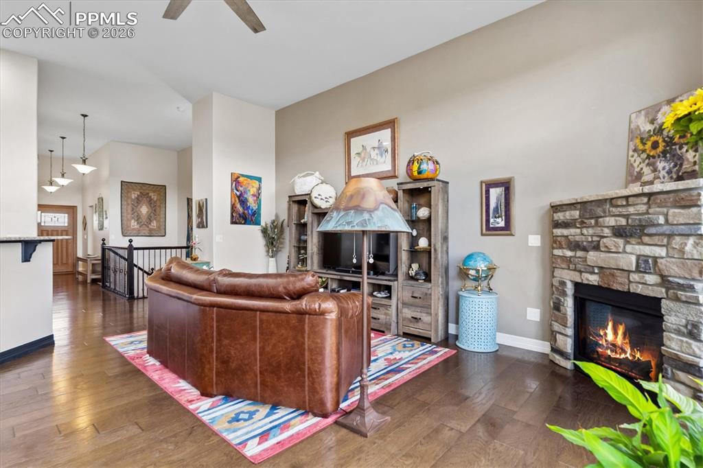 Image 13 of 48: Living room with dark wood finished floors, ceiling fan, a high ceiling, an