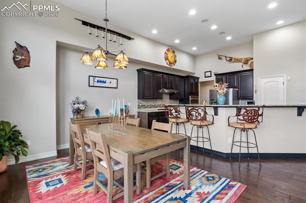 Image 14 of 48: Living room featuring dark wood-style flooring, a stone fireplace, a ceilin