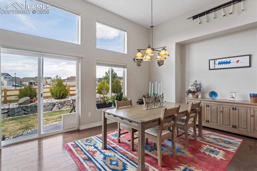 Image 15 of 48: Dining room featuring dark wood-style flooring, recessed lighting, and a hi