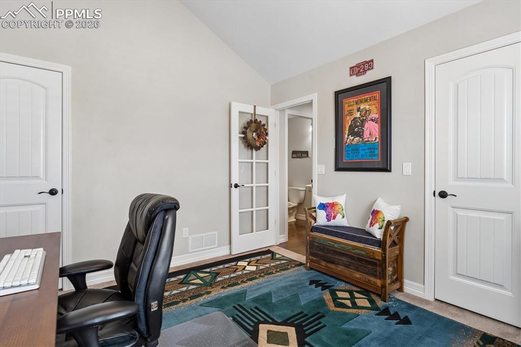 Image 24 of 48: Carpeted office featuring baseboards and lofted ceiling