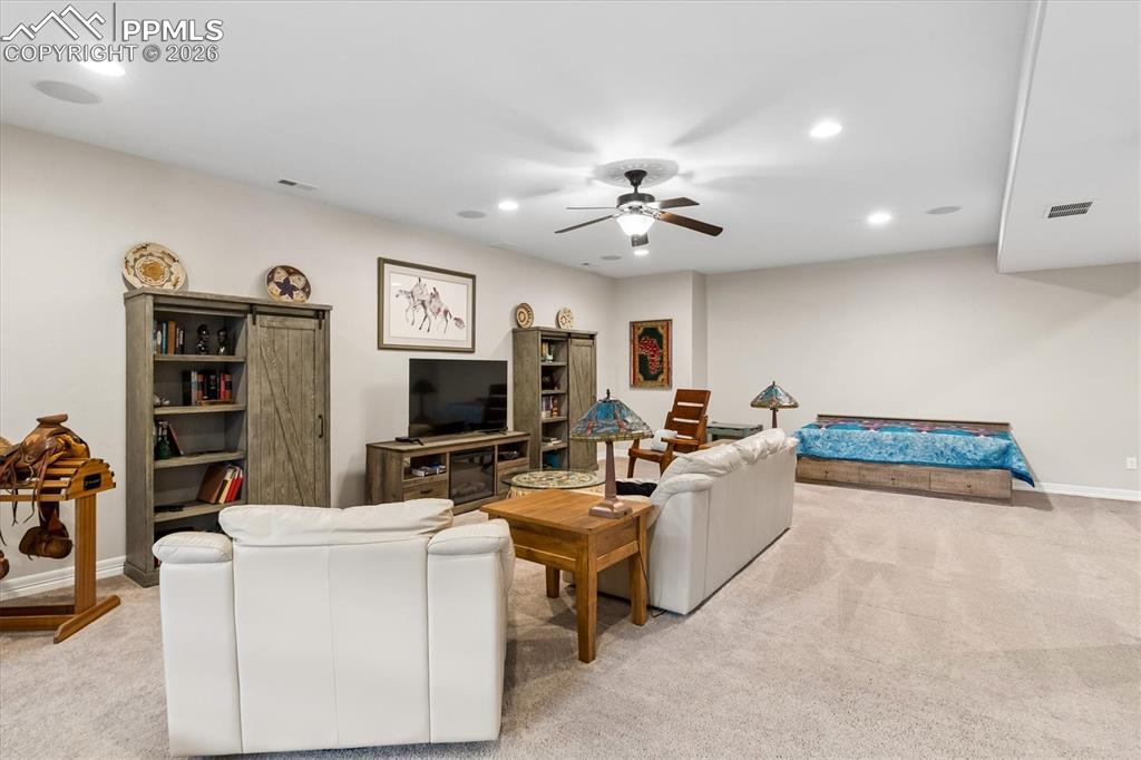 Image 32 of 48: Living area featuring light carpet, a ceiling fan, and recessed lighting