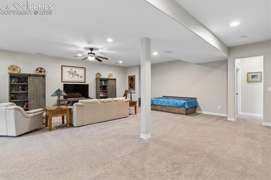 Image 33 of 48: Living room featuring light colored carpet, a ceiling fan, and recessed lig