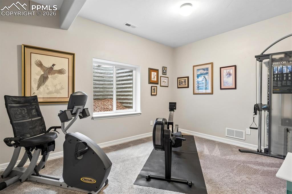 Image 41 of 48: Bathroom with double vanity, a shower with curtain, and stone finish floors