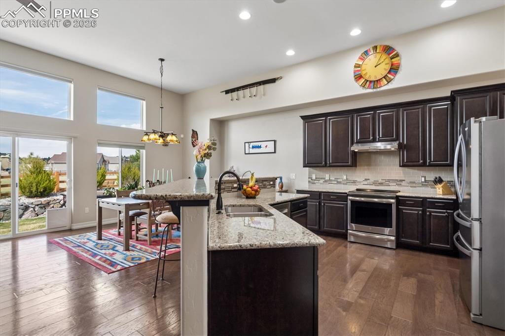 Image 8 of 48: Kitchen featuring dark wood finish cabinetry, stainless steel appliances, l