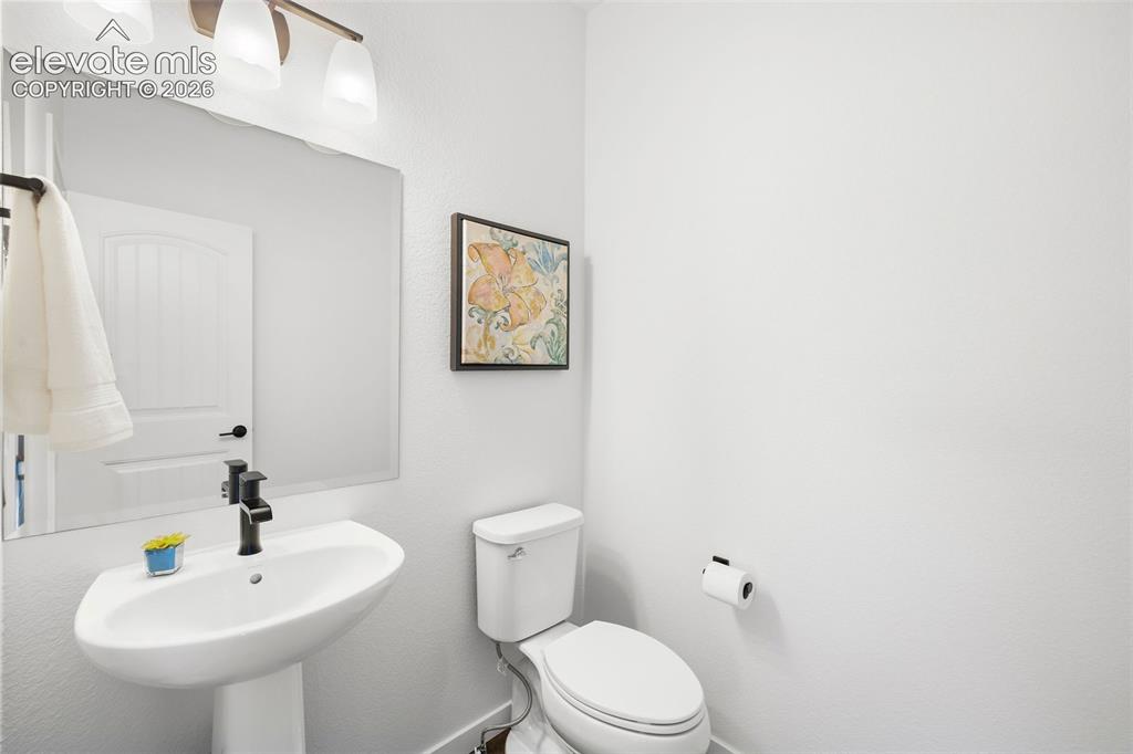 Image 15 of 46: This powder room serves the main level and features a pedestal sing and bro