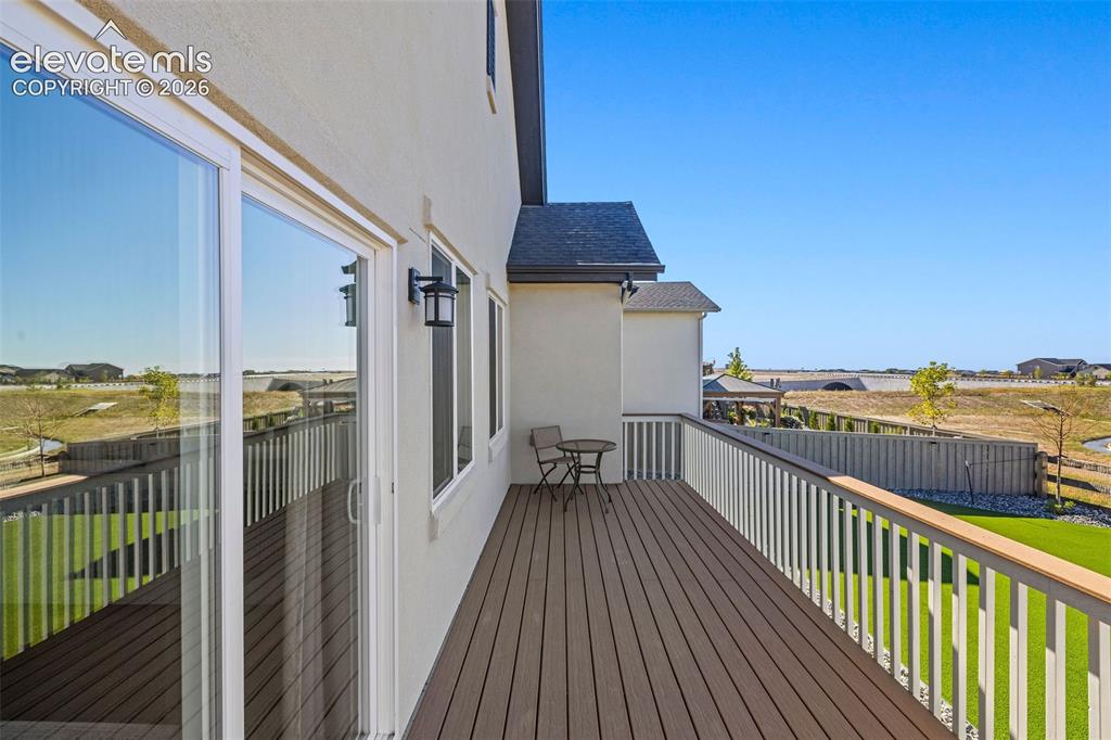 Image 33 of 46: The open composite deck has incredible views of the green belt in the back