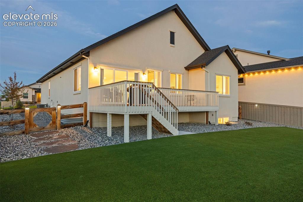 Image 37 of 46: The back yard is fully fenched and the lawn is edged with xeriscaping to cu