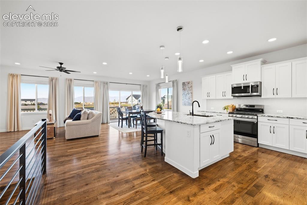 Image 5 of 46: An open layout connects the kitchen, dining area, and living room. Island s