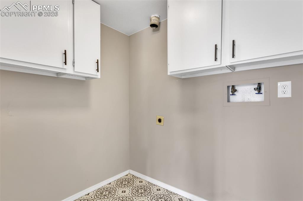 Image 13 of 30: Laundry area with cabinet space, hookup for an electric dryer, and hookup f