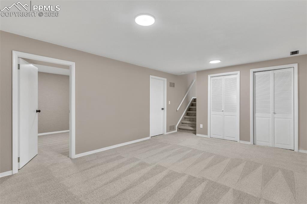 Image 15 of 30: Unfurnished bedroom featuring multiple closets and light colored carpet