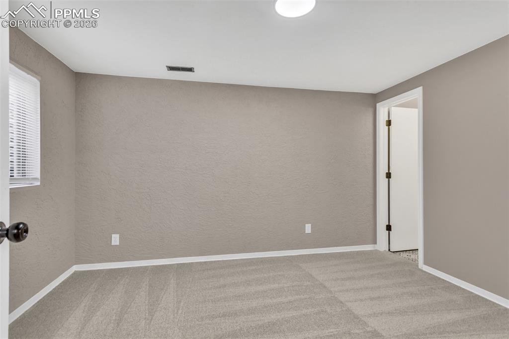 Image 16 of 30: Unfurnished room featuring light colored carpet and a textured wall