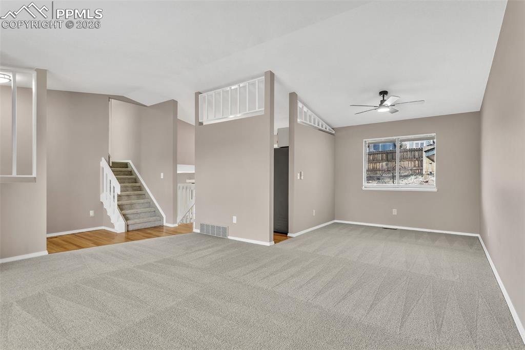 Image 2 of 30: Unfurnished living room featuring light carpet and ceiling fan